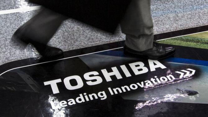 Man walks past logo of Toshiba Corp at electronics store in Tokyo