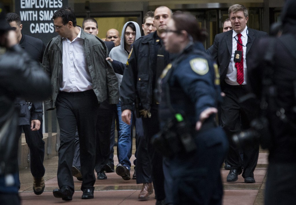 Martin Shkreli, chief executive officer of Turing Pharmaceuticals LLC, center, and attorney Evan Greebel, left, exit federal court in New York, U.S., on Thursday, Dec. 17, 2015. Shkreli was arrested on alleged securities fraud related to Retrophin Inc., a biotech firm he founded in 2011. Greebel is accused of conspiring with Shkreli in part of the scheme. Photographer: John Taggart/Bloomberg *** Local Caption *** Martin Shkreli; Evan Greebel